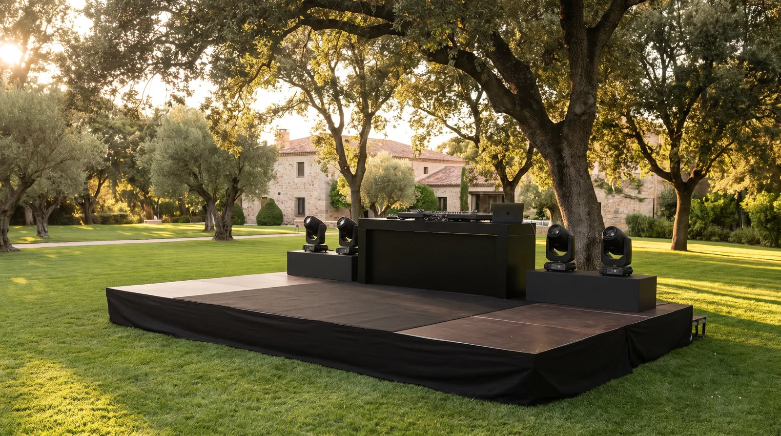 Tarima para eventos montada con equipo de sonido e iluminación en el jardín de una finca en Madrid.
